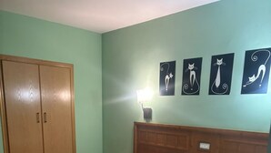 A bedroom with a bed, a wardrobe, a nightstand, and wall art. - HOTEL RESTAURANTE LA BARCA (Pedro Munoz)