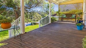 A wooden deck with a railing, potted plants, and a covered seating area. - A Peaceful Haven Only A Few Minutes Walk To Town (KATOOMBA)