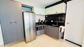 Eine moderne Küche mit einem Edelstahl-Kühlschrank, einer Mikrowelle und einer Kaffeemaschine.