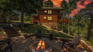 A log cabin with a fire pit, outdoor seating, and a deck. - Little Bear: 3-bedroom cabin with Hot Tub, Putt Putt, Game Room & Fire Pit (Sevierville)