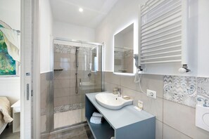 Une salle de bain moderne avec une douche à parois de verre, un meuble-lavabo et des carreaux décoratifs sur les murs.