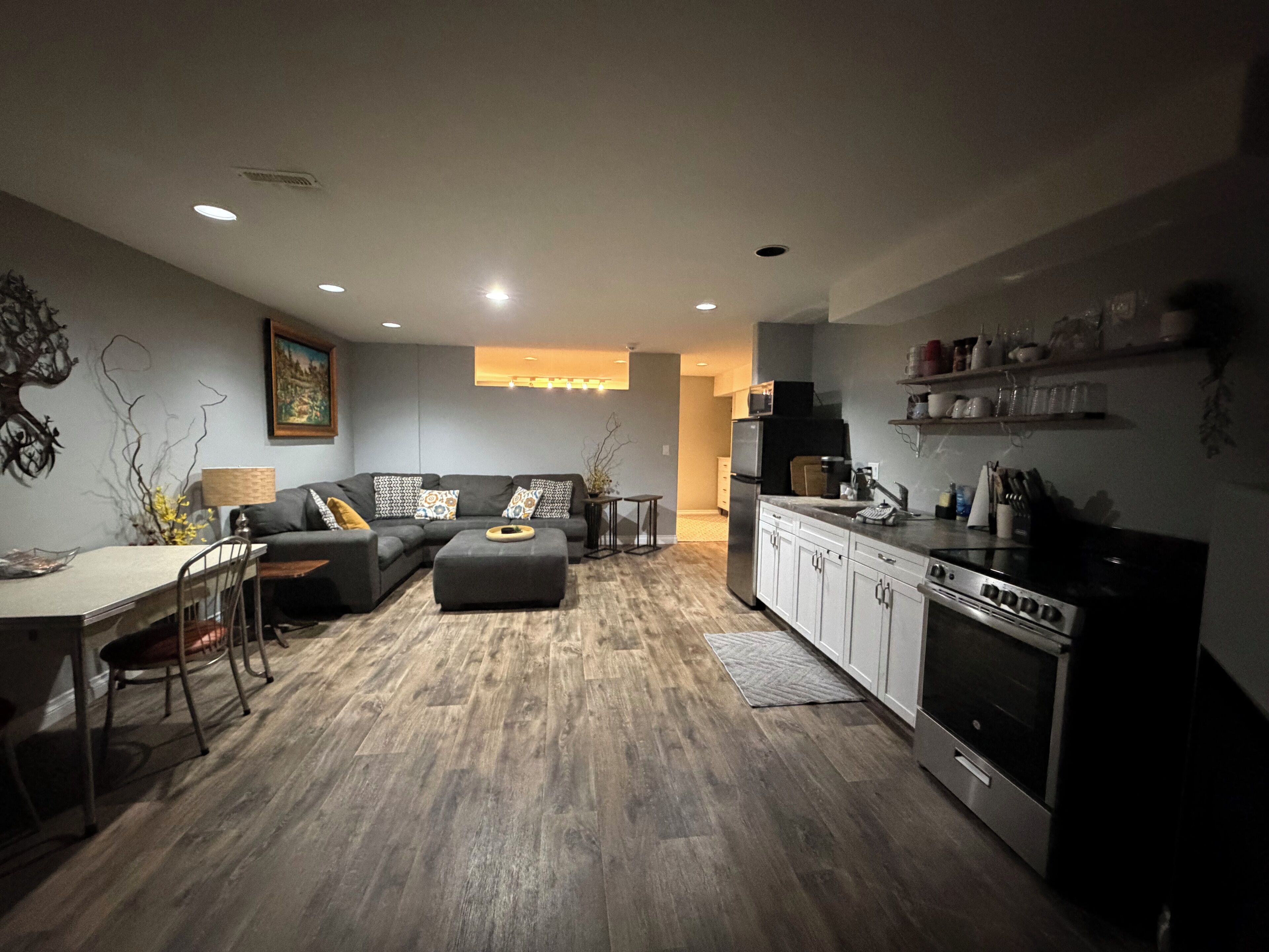 Un salon moderne avec un canapé, un pouf et une table à manger.