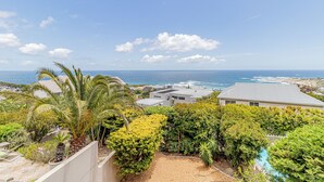 A residential area with a view of the ocean, houses, and a swimming pool. - Stunning 2-bedroom apartment in gorgeous Camps Bay - 5 mins from the beach. (Cape Town)