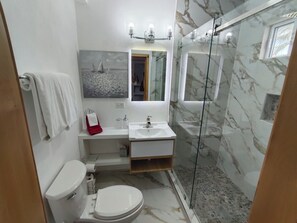 Ein modernes Badezimmer mit Toilette, Waschbecken und einer Duschkabine.