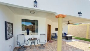 A patio with a table and chairs, a window, and a door.
