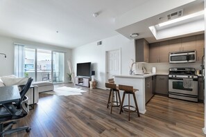 Ein modernes Apartment mit Wohnzimmer, Küche und Essbereich.