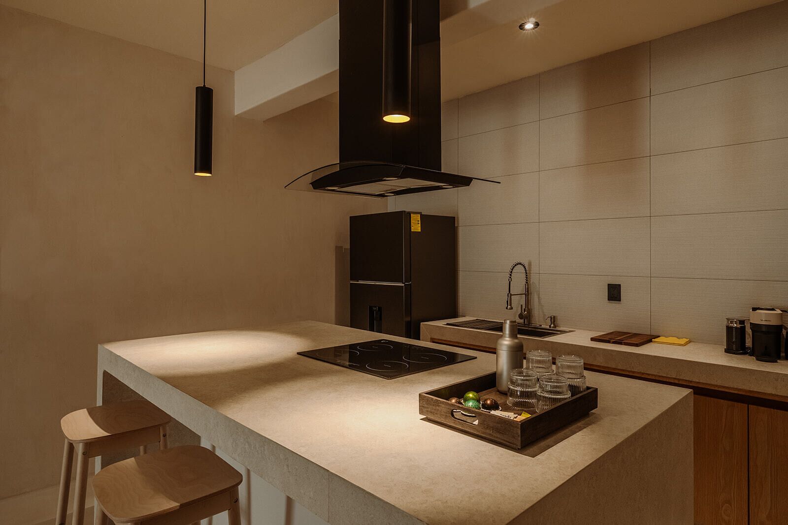 Une cuisine moderne dotée d’un îlot central, d’appareils électroménagers intégrés et d’un design minimaliste.