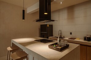 A modern kitchen with a central island, built-in appliances, and a minimalist design. - Zima Stays (Acapulco)