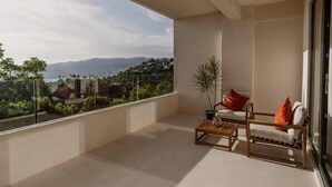 A balcony with a view of a cityscape and mountains.