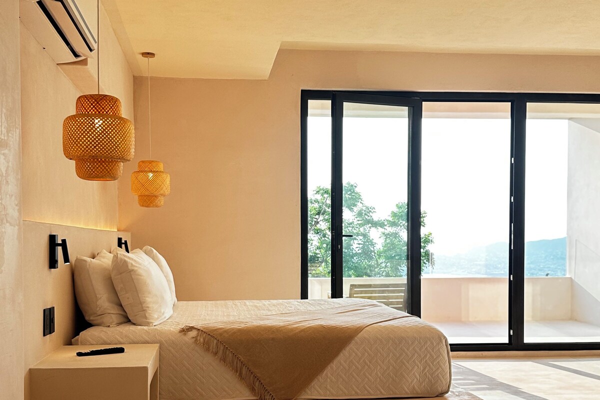 A modern bedroom with a bed, bedside table, and a large window with a view.