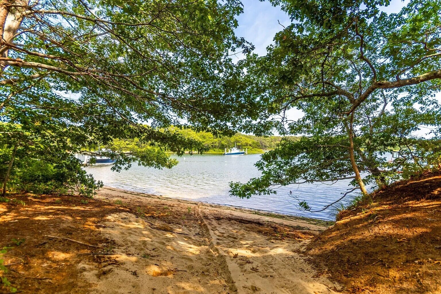 Ein Sandstrand mit einem See und einem Boot.