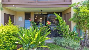 A two-story building with a balcony, a covered patio, and various plants. - Paradise Awaits at This Beautiful Waikoloa Village Condo! (Waikoloa Village)