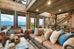 Ein gemütliches Wohnzimmer mit Ledersofa, Holzelementen und Blick ins Freie.