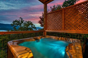 Ein Whirlpool mit Blick auf Berge und einen Sonnenuntergang.