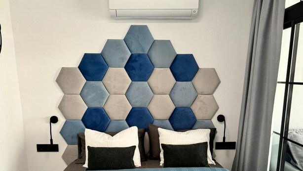A modern hotel room with a geometric-patterned headboard, a large window with curtains, and a central air conditioning unit. - Modern Premium Apartment Near Ccyumbo (San Bartolomé de Tirajana)