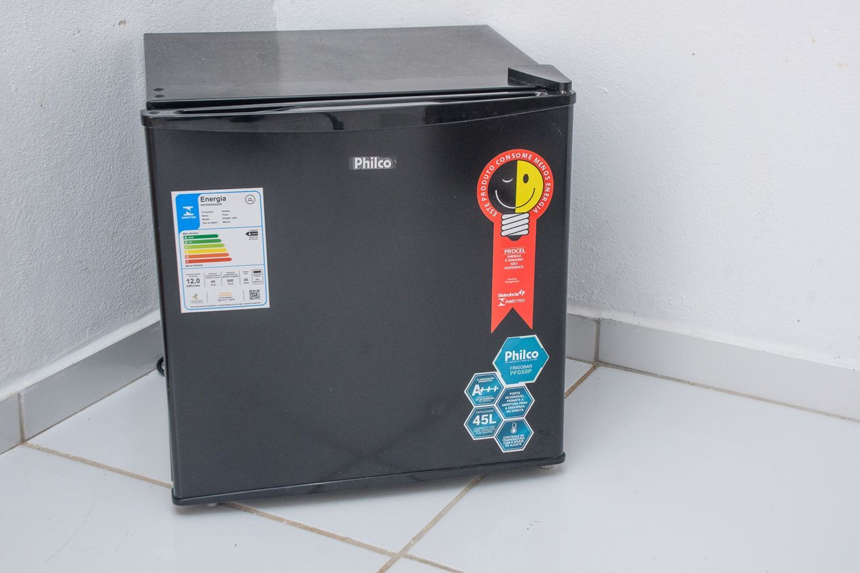 A black Philco refrigerator with energy efficiency labels and a red ribbon sticker.