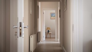 A hallway with a radiator, a lamp on a small table, and a framed picture on the wall. - Tranquil 7-bedroom villa in charming Dundrum perfect for groups and families. (Dundrum)