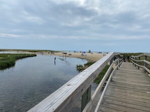 A wooden boardwalk leading to a beach with people and tents. - Modern, Newly Renovated, 3-bed Peach Tree House (Chatham)