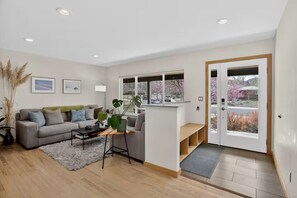 A modern living room with a sofa, coffee table, and plants. - Central Boulder, Modern Comfort Close to CU, Chautauqua, and Pearl Street (Boulder)
