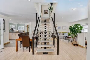 A modern interior with a staircase, dining area, and a large plant. - Central Boulder, Modern Comfort Close to CU, Chautauqua, and Pearl Street (Boulder)