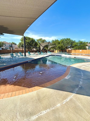 Una piscina con lettini e un'area coperta.
