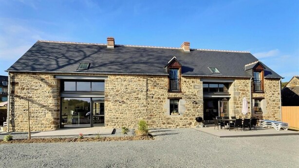 A stone building with large windows, a covered patio, and outdoor seating. - l'Escale 1822 - QUEBRIAC (QUEBRIAC)