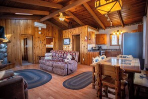 Ein gemütliches Blockhaus-Interieur mit Wohnbereich, Essbereich und Küche.