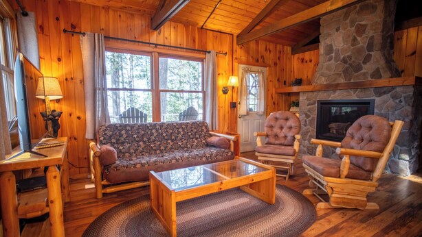 A wooden interior with a sofa, two armchairs, a coffee table, and a stone fireplace. - Prime location: The Coyote Cabin (Babbitt)