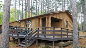A log cabin with a wooden deck and stairs leading to a porch. - For our honeymooners: The Hummingbird Cabin (Babbitt)