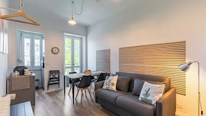 A modern living room with a sofa, dining table, and kitchen area. - In Turin bright apartment, for those seeking comfort and tranquility (Torino)
