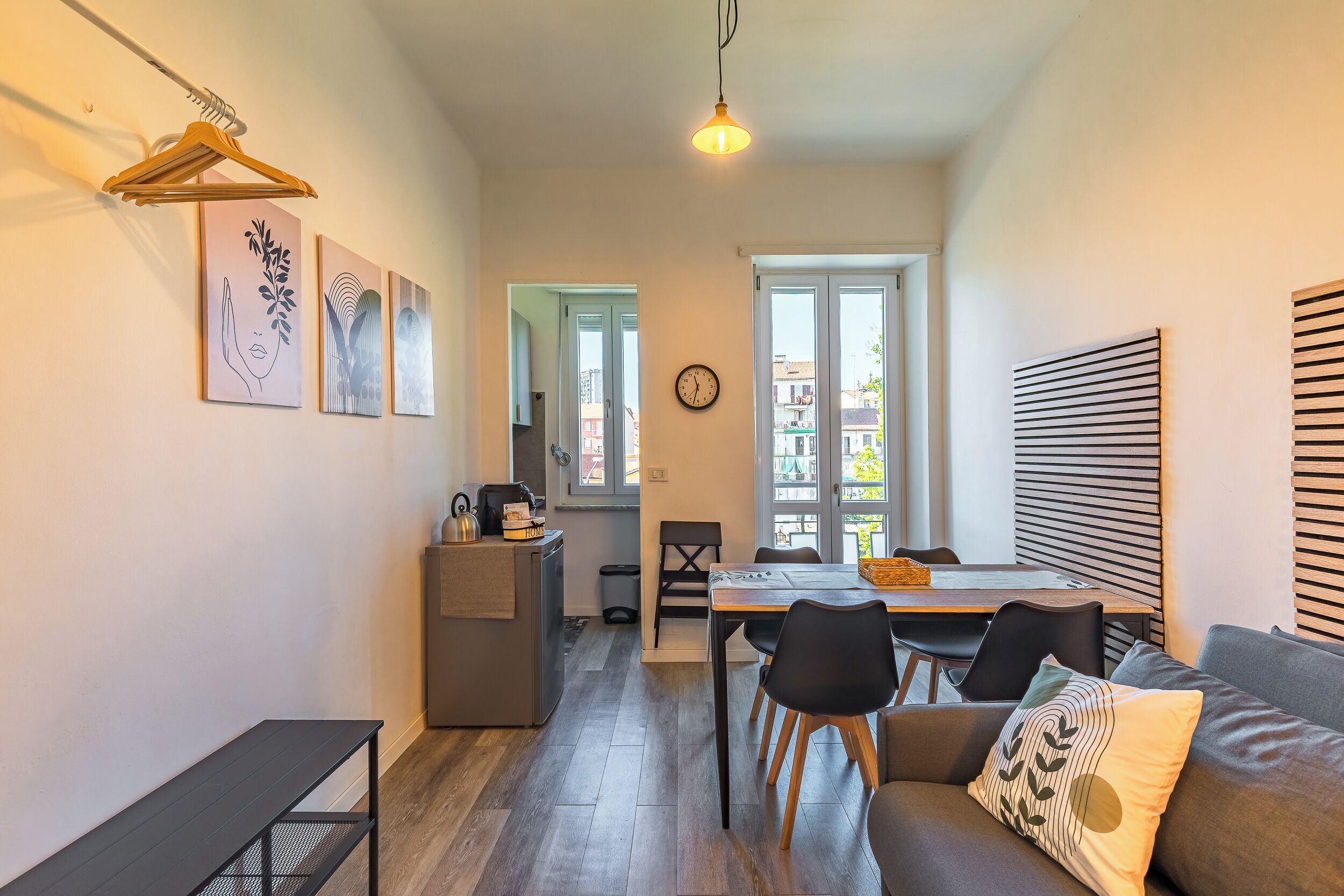 Un interior moderno con comedor, sofá y obras de arte en las paredes.