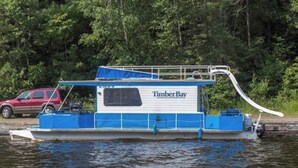 Un bateau doté d’une cabine portant l’inscription « Timber Bay » et d’une zone de pont couverte.