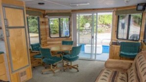 Habitación compacta con sofá, sillas, una mesita y ventana.