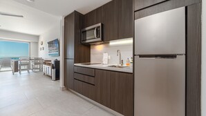 A modern kitchen with dark wood cabinetry, stainless steel appliances, and a view to the outside. - Sonoran Star One 1203a (Puerto Peñasco)