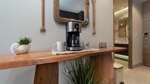 Eine Holztischplatte mit einer Kaffeemaschine, einem Blumentopf und zwei Tassen.