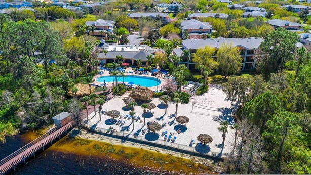 An aerial view of a resort with a central pool, beach area, and a bridge over water. - Go 13 - Bahama BAY in Davenport (Davenport)