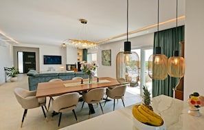 A modern dining area with a wooden table, chairs, and a decorative pineapple centerpiece. - Awesome home in Porec (Porec)