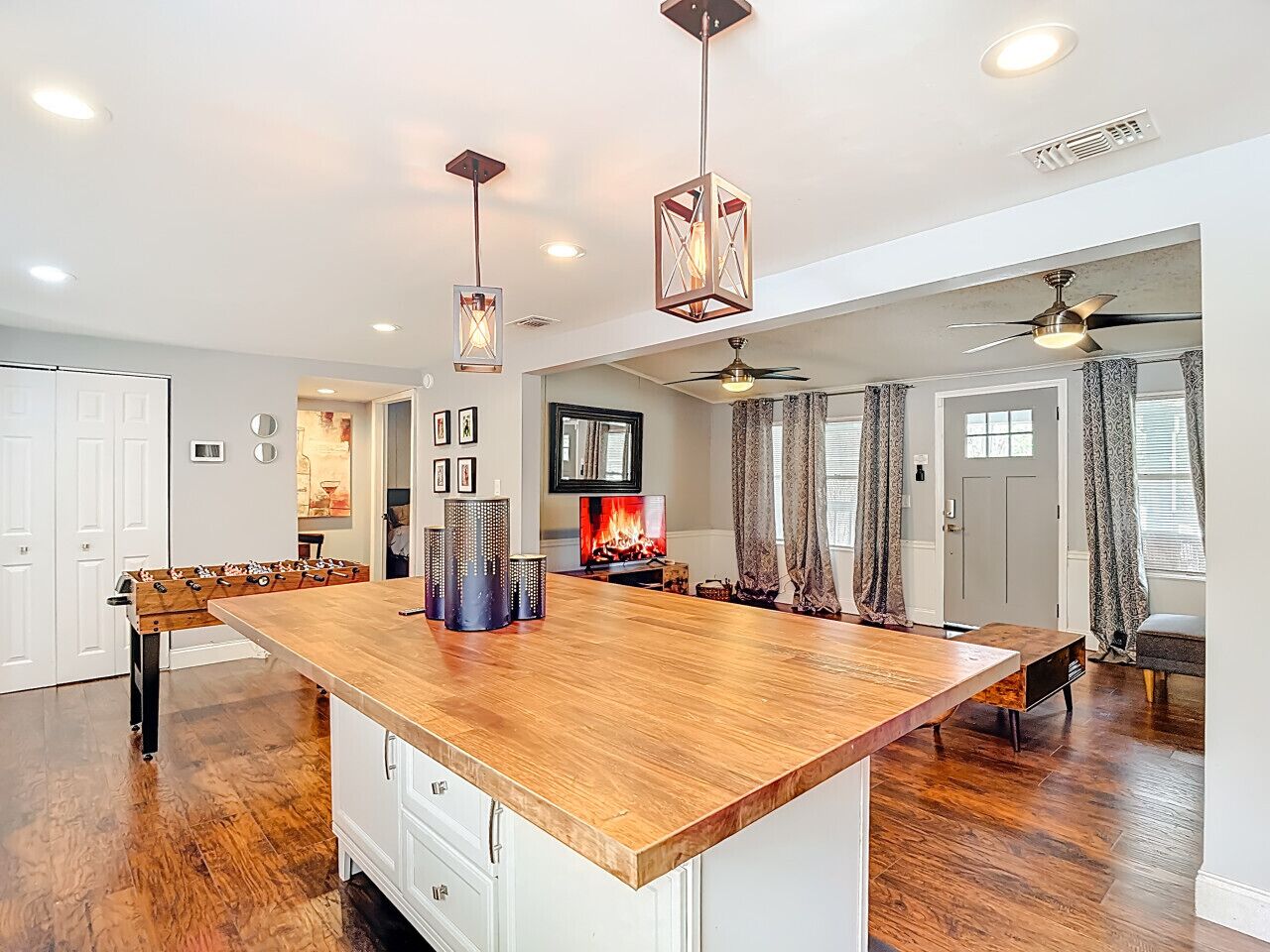 A spacious kitchen with a large island, pendant lighting, and a ceiling fan.