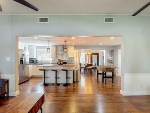 A spacious kitchen with a central island, bar stools, and a dining area with chairs. - Private Pool, Games, Firepit Ultimate Tampa Fun House (Tampa)