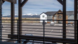 A parking lot with a view of a building with a wooden facade and a mountain backdrop. - Two-bedroom Flat at Teton Peaks (Driggs)