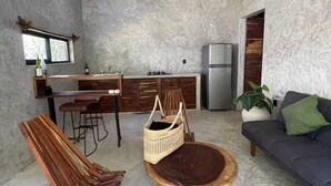 Una cuina compacta amb zona de menjador, un sofà i un ventilador de sostre.