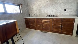 Cuina amb taulell, armaris i finestra.