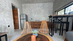 Een moderne keuken met een houten eettafel, stoelen en een koelkast.