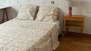 Ein Schlafzimmer mit einem Bett, einem Nachttisch und einer Lampe.