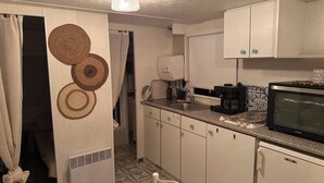 A compact kitchen with a microwave, coffee maker, and a small refrigerator.