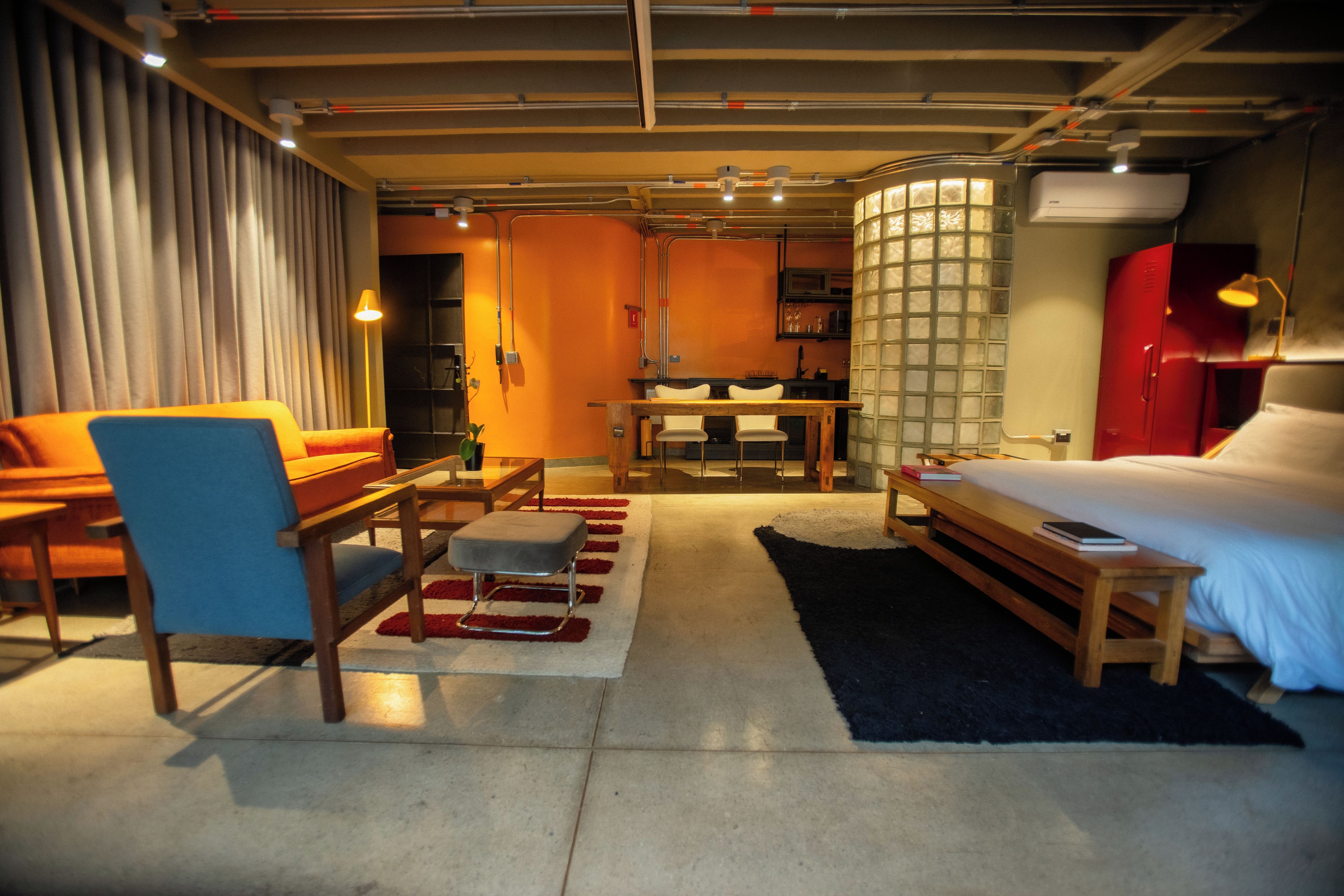 Una habitación de hotel con cama, escritorio, silla, sofá y mesa de comedor.