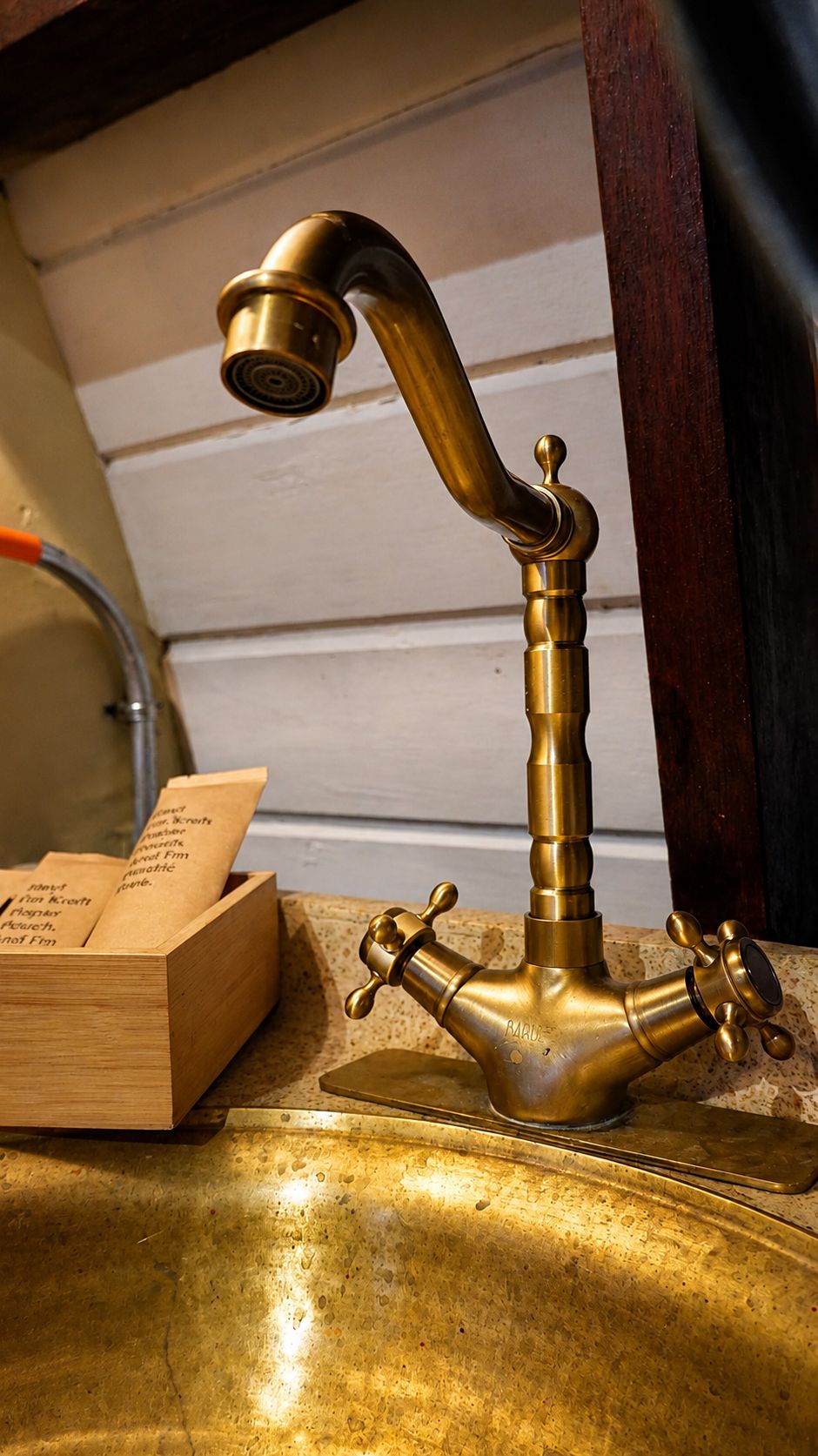 A brass faucet with a curved spout and two handles, placed on a countertop.