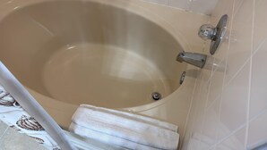A bathtub with a drain, a faucet, and a towel on the floor. - 130 Napoli Dr, Davenport - Regal Palms Resort (Davenport)