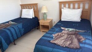 Two twin beds with Star Wars-themed bedding, a bedside lamp, and a nightstand. - 130 Napoli Dr, Davenport - Regal Palms Resort (Davenport)