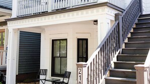 A two-story house with a balcony, a staircase, and a garage door. - Stunning Downtown 3BD-2.5BA Home| Near Forsyth Pk (Savannah)